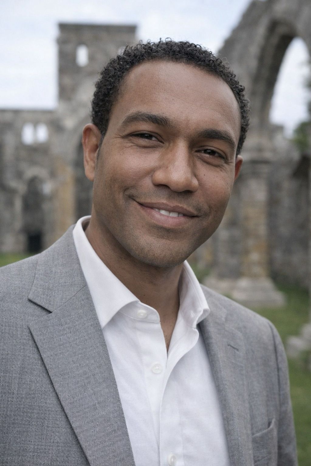 Belcario Thomas, smiling, standing in front of the Unfinished Church in St. George's, Bermuda